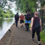 team members walking along tow path of canal